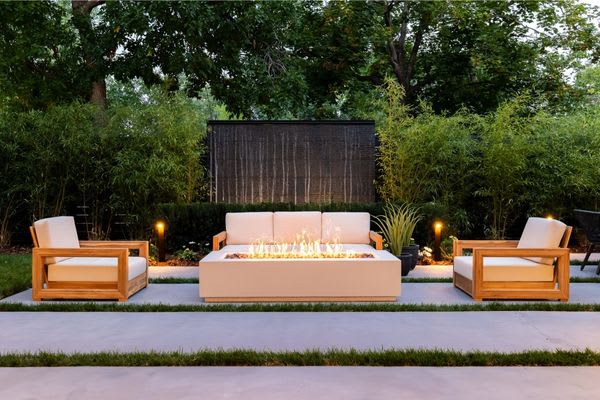 backyard at dusk with firepit lit in the middle of furniture
